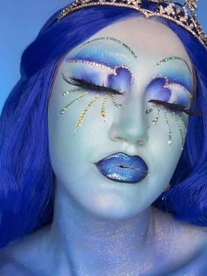 A post by @katiefarhood on TikTok caption: I was so obsessed with these makeup looks by @Ellis_Atlantis, so I decided to blend the two together 🩵💙 #makeuptutorial #editorialmakeup #dragmakeup #rhinestonemakeup #creativemakeup #funmakeup #bluemakeup #colorfulmakeup #greenscreen 