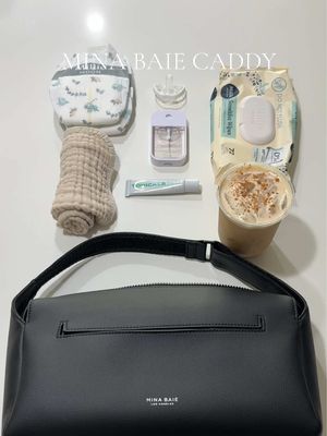 A post by @sheenaabrooks on TikTok caption: diaper caddy with a cup holder is perfect for a morning walk - 🖤 @MINA BAIE #minabaie #diaperbag #momlife #whatsinmydiaperbag 