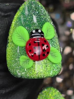 A post by @ilysmnails on TikTok caption: Are you Team 'LISA' or Team Jennie? Alter Ego or Ruby? 🐞 🍃 These Nails give a 'Lisa' vibe! Green Polish with Cateye Reflective Glitter. This cute lady bug is flying high with Leaf wings! ilysmnails .com #nails #nailsart #satisfying #beautyhacks #asmr 