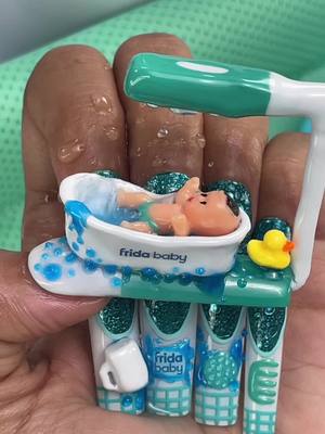 A post by @ilysmnails on TikTok caption: Baby Taking a Relaxing Bath on my NAILS! 👶🚿🛁 So Cute!! Created this minature bath & functional shower as Nail Art. ASMR & Unboxing Control The Flow Bath Sprayer @Frida Baby and Frida Mom #nailart #Art #satisfying #baby #asmr 