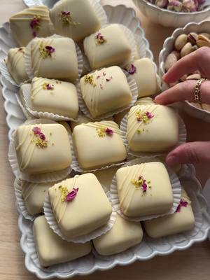 A post by @kookmutsjes on TikTok caption: PISTACHIO SANDWICH COOKIES WITH WHITE CHOCOLATE #food #recipe #chocolate #cookies #pistachios #chocolate #eid #ramadan #ramadan2025 #fyp     COOKIE DOUGH 150 g unsalted butter 100 g powdered sugar 8 g vanilla sugar (1 packet) pinch of salt 1 medium egg 50 g unsalted pistachios 290 g flour (all-purpose flour) 3 g baking powder FILLING pistachio paste COATING 300 g white chocolate GARNISH white chocolate chopped pistachios edible rose petals Instructions: Finely grind the pistachios in a food processor. In a bowl, mix the softened butter, powdered sugar, vanilla sugar, and salt until smooth. Add the egg and ground pistachios, mix well. Add the flour and baking powder, and knead until smooth. Lightly flour your work surface and roll out the cookie dough to just under 1 cm thick. Use a cookie cutter to cut out your desired shapes. Place the cookies on a baking sheet lined with parchment paper. Bake in a preheated oven at 190 °C (375 °F) for 10-12 minutes, or until lightly golden brown. Let them cool completely. Spread a layer of pistachio paste on one cookie and place another cookie on top. Repeat with the remaining cookies. Melt the white chocolate using a double boiler: fill a saucepan with 2 cm of water and bring to a boil.  Place a heatproof bowl over the saucepan (without touching the water). Add the white chocolate pieces and let them slowly melt, stirring occasionally until smooth. Dip each cookie sandwich into the melted white chocolate and place them on parchment paper. Decorate with thin lines of white chocolate, chopped pistachios, and edible rose petals. Let the chocolate fully harden. Tips: Once the flour is added, knead the dough briefly. Over-kneading makes the cookies chewy instead of crumbly. Wrap the dough in plastic wrap and let it rest in the refrigerator for at least 30 minutes. This makes the dough firmer and prevents the cookies from spreading during baking. Roll out the dough evenly (use a rolling pin with rings or two wooden slats of the same thickness as guides). Every oven is different, so check after 10 minutes to see if the cookies are golden brown. If short on time, chill the cookies for 10-15 minutes in the fridge to set the chocolate faster. Decorate the cookies as desired.