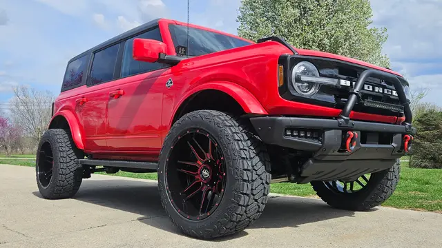 A post by @jasonmudd09 on TikTok caption: 2014 outerbanks bronco on 22x12 XF 222 and 35 x12.50 kelfire DMR RT .3 inch rough country lift . mctuning rock lights , rough country 20 inch light bar between the bull bar and 2 inch pod lights by the mirrors . #bronco #lift #mallcrawler