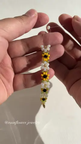 A post by @rainflower.jewelry on TikTok caption: Available 🌻🤍🌱💫 #sunflowerbracelet #daisybracelet #floraljewelry #handmadebracelet #beadedjewelry #bohostyle #aestheticaccessories #cottagecoreaesthetic #braceletstack #natureinspired #trendyjewelry #smallbusinesslove #supporthandmade #giftideas #fyp #viralfinds #summerfashion #freeworldwideshipping 