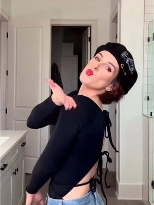 A post by @shenaegrimesbeech on TikTok caption: The power of a hat + red lip is underrated #makeuptutorial #makeup #redlips #grwm #badhairday 