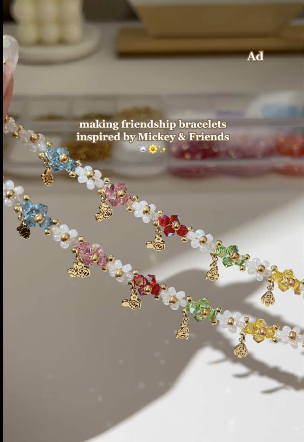 A post by @bijouxkomorebi on TikTok caption: #ad creating friendship bracelets inspired by Mickey & Friends! 🐭🌼✨ tag your bestie in the comments 🫶🏼 @Disney  #handmadejewelry #beadedbracelet #beadedjewelry #daisybracelet #beadeddaisybracelet #beadjewlery