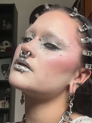 A post by @motherof.hades on TikTok caption: STUNNINGGGGGAH 💁🏻‍♀️#motherofhades #foryou #fyp #trending #facepiercings #creativemakeup #goth #gothmakeup #silver #silvermakeup #3dmakeup #MakeUpArtist #glittermakeup 