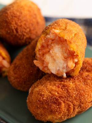 A post by @giallolovesitaly on TikTok caption: Say ciao to the ultimate Roman street food: supplì al telefono! 📞🧀 Crispy on the outside, melty mozzarella on the inside, and packed with tomato-flavored rice goodness❤️🤤 @ludovicagargari Ingredients: 2 cups Arborio or Carnaroli rice (400 g) 4 cups vegetable broth (1 liter) 7 oz mozzarella, cut into small cubes (200 g) ½ cup grated Parmesan cheese (50 g) 3 eggs 1 cup tomato purée (passata) (250 ml) All-purpose flour, as needed Breadcrumbs, as needed Vegetable oil, for frying Salt and black pepper, to taste White wine, for deglazing (a splash) #giallolovesitaly #supplì #romancuisine #foodtok