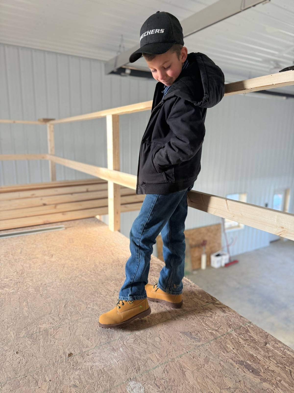 A post by @justajacksonthing on TikTok caption: Jackson’s enjoying the comfort of his new Skechers Rugged Dozer Boots while getting work done in the new shop on the farm. #skecherspartner #skechersxjohndeere #justajacksonthing