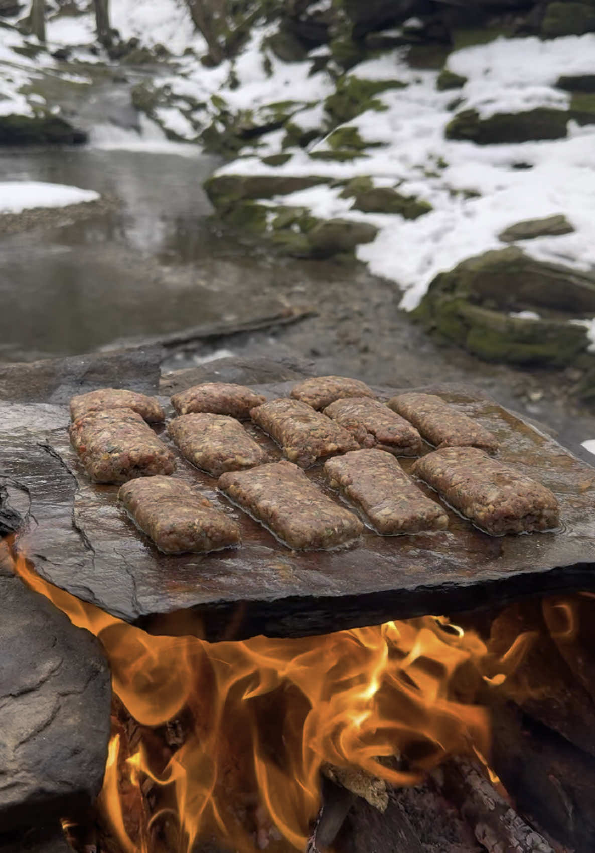 A post by @karadenizli.maceraci on TikTok caption: Taş Üzerinde Rulo Köfte Sarma 🫓🥩 Meatball roll on stone  #outdoors #cookingvideo #asmrsounds #nature #foodvideos #asmrvideo #asmrfood #recipe #survival #cooking #foodporn #adventure 
