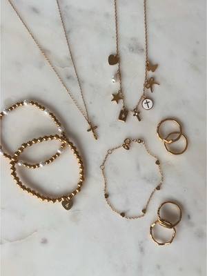 A post by @elevatedfaith on TikTok caption: A touch of gold to add to your next outfit ✨ Shop all Scripture-based jewelry at the link in our bio!