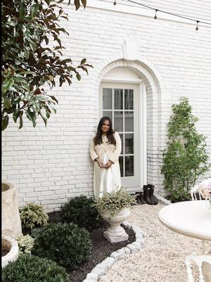 A post by @nabela on TikTok caption: & the day has come… from a vision to a moodboard to my dream courtyard oasis. an idyllic escape transporting me to the European countryside with enduring treasures from @oliveateliers, thanks to the OA concierge program: a complimentary service that offers design guidance and personalized shopping from afar, making my antique limestone fountains, custom dining table, vintage + antique vessels, limestone bench & so much more actually tangible. what a journey this project has been, with many more to come. 🕊️  #nabelanoorhome #transformation #design #renovation #outdoors #garden #newhome #diy #decor 