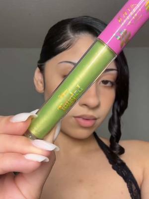 A post by @colourpopco on TikTok caption: We're actually obsessed with this green Ultra Glossy Lip from our Disney Tangled by ColourPop collection. 🦎✨ @La China 🫶🏼 wearing Pascal, a sheer golden lime shade. 💚  Grab these NEW limited-edition shades now on TikTok Shop. 🏰✨🛍️