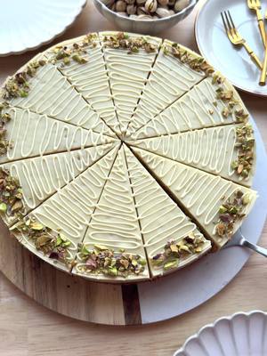 A post by @kookmutsjes on TikTok caption: PISTACHIO CAKE WITH FILLING AND CHOCOLATE #food #recipe #pistachio #cake #tasty #fyp #fy #foryou #chocolate CAKE BATTER 4 eggs (medium) 140 g granulated sugar 8 g vanilla sugar (1 packet) 50 g unsalted pistachios 165 ml sunflower oil 150 ml milk  200 g flour (all-purpose flour) 10 g baking powder PISTACHIO MIXTURE 300 ml milk (full-fat milk) 30 g cornstarch 25 g granulated sugar 8 g vanilla sugar (1 packet) 100 g white chocolate 90 g pistachio paste GANACHE 40 ml heavy cream 125 g white chocolate GARNISH melted white chocolate unsalted pistachios Instructions: Grind the pistachios in a food processor. Crack the eggs into a deep bowl and add the granulated sugar and vanilla sugar. Mix for 5–7 minutes until the mixture is light yellow and airy. Add the ground pistachios, sunflower oil, and milk. Mix briefly. Sift the flour and baking powder over the bowl and mix until smooth. Pour 400 g of the cake batter into a springform pan lined with parchment paper. Place the cake in a preheated oven at 175°C (350°F). Bake for 10 minutes. Meanwhile, prepare the pistachio mixture: Heat the milk together with the granulated sugar, vanilla sugar, and cornstarch in a pan over medium heat. Stir constantly with a whisk until the mixture thickens. Remove the pan from the heat, add the white chocolate, and let it sit for 1 minute. Stir until the chocolate is completely melted. Add the pistachio paste and mix until smooth. Transfer the pistachio mixture to a piping bag and set aside. After 10 minutes, carefully remove the cake from the oven. Pipe the pistachio mixture evenly over the cake. Pour the remaining cake batter over it. Return the cake to the oven and bake for another 30 minutes at 175°C (350°F), or until the cake is fully baked (check by inserting a skewer; each oven varies).  Let the cake cool completely. Heat the heavy cream just below boiling point. Add the white chocolate (125 g), let it sit for 1 minute, and stir until smooth. Let it cool. Pour the cooled ganache over the cake. Cover and refrigerate for at least one night to set. Slice the cake into pieces. Garnish each piece with lines of melted white chocolate and sprinkle with finely chopped pistachios. Tips: A little texture in the finely ground pistachios (not fully powdered) adds extra flavor and a nice bite to the cake. Ovens can vary! Stick a skewer in the center of the cake. If it comes out (almost) dry, the cake is done. A few moist crumbs are okay, but not runny batter. Let the cake cool completely before pouring the ganache over it. Use a sharp knife when slicing. For neat, clean cuts, run your knife under hot water and wipe it clean after each slice. This will keep the edges crisp! Make the cake a day ahead. The flavors develop better if the cake sits overnight in the fridge. The texture will also improve! I used a 24 cm springform pan.