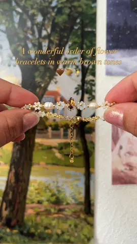 A post by @rainflower.jewelry on TikTok caption: A beautiful custom order for @Monique 🍓 in cozy brown tones🤎 Every order comes with a personalized gift! You can shop through the link in my bio💫 #customorder #floraljewelry #daisybracelet #brownfashion #smallbusinesscheck #beadedbracelets #beadedjewelry 