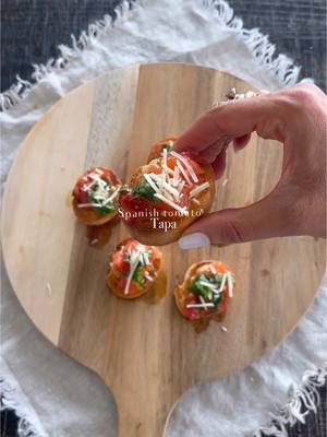 A post by @spanglishfashion on TikTok caption: Mini Spanish tomato basil tapa 🍅🥖 #tapas ( Paella Fest tapas 🇪🇸) Ingredients: - Tomatoes - Garlic - Extra virgen Olive oil - Fresh Basil - Parmesan cheese - Salt and Pepper - Cayenne pepper #tapasespañolas #minibread #tapas #bruchetta #tomatoes #basil #spanglishfashioncuisine