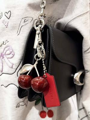 A post by @coach on TikTok caption: Matching your hangtag to your charms >>> #CoachNY 