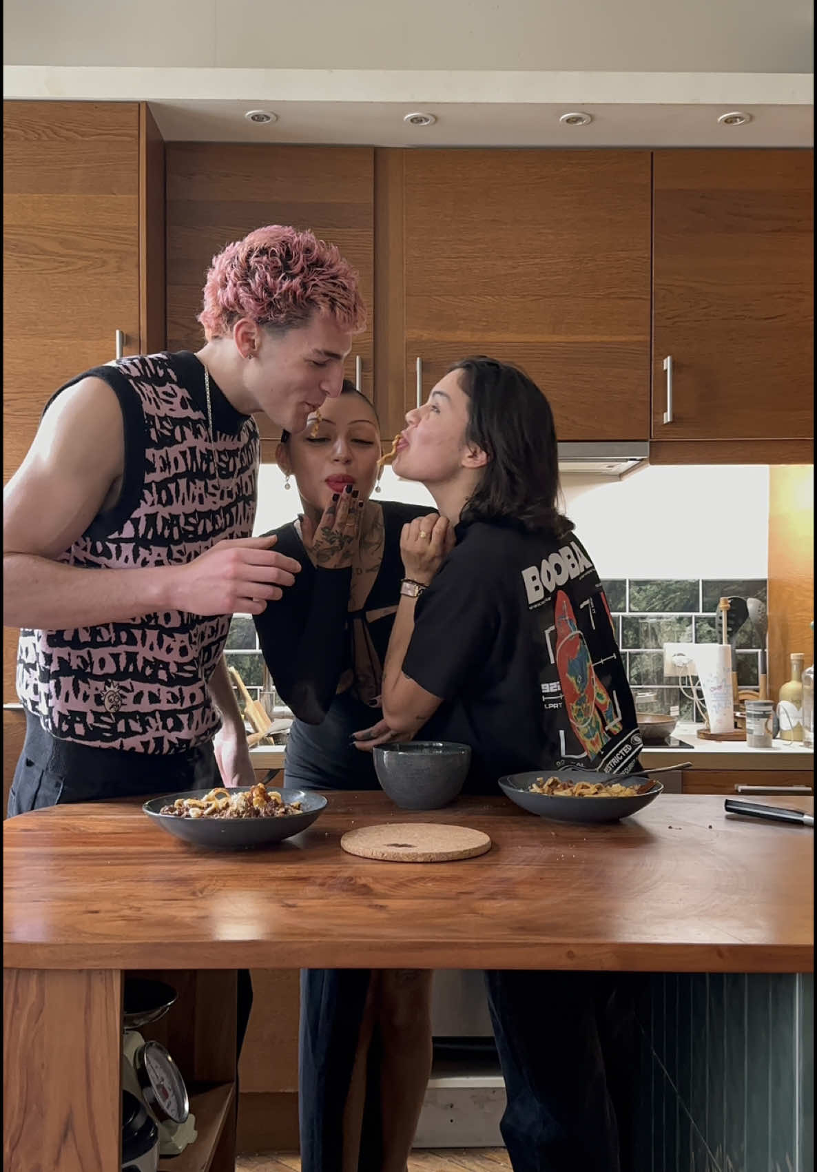A post by @abitewithogee on TikTok caption: Guest edition with @lola / @Milhan 🍝🖤 Pasta Bolognese 🍝  Start by bringing the pasta water to a boil. Finely chop the onions, garlic, carrots, and mortadella. Put the vegetables in a pan with butter. After 5 minutes, add the mortadella and the two ground meats (beef and sausage) until browned. Deglaze with red wine until almost completely evaporated. Add the tomato sauce and broth. Add the herbs and spices, and season with salt and pepper. Simmer for a good 12 minutes while the pasta cooks. Serve with Parmesan cheese.	 🇫🇷 Commencez par mettre l’eau des pâtes à bouillir. Hachez finement les les oignons, l’ail, les carottes et la mortadelle. Faire revenir les légumes dans une poêle avec du beurre. Après 5 minutes rajoutez la mortadelle et les deux viandes hachées (boeuf et chaire à saucisse) jusqu’à ce que tout soit doré. Déglacez avec du vin rouge jusqu’à quasi complète évaporation. Ajoutez la sauce tomate et le bouillon. Ajoutez les herbes et les épices, salez, poivrez. Laissez mijoter une bonne douzaine de minutes pendant que les pâtes cuisent. Servez avec du parmesan. Ogee is wearing a @Nensi Dojaka dress and @Prada heels. #ABiteWithOgee 🖤