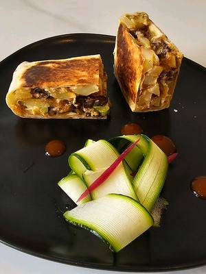 A post by @nabil_zemmouri on TikTok caption: Recette Tacos Lyonnais pour 4:  (Pour en faire 4 pour moins de 8euros en tout soit moins de 2euros par tacos j'ai fait mes courses chez @E.Leclerc ):  1 paquet de farine  1 petit paquet de chapelure  4 pommes de terre  1 petit pot de crème fraîche  1 petit paquet d’emmental  1 grande courgette 2 oignons  Une dizaines de champignons  Déroulé : Mélanger 500 gr de farine avec càc de levure chimique (optionnel) une pincée de sel et de sucre. Ajouter 250gr d’eau  et pétrir. Étalez le plus finement possible en farinant chaque face et cuire sur feu moyen. Couvrir d’un torchon humide et renouveler Mélanger 1 volume de farine 1 volume de chapelure et 2 volume d’eau avec une pincée de sel et de curry (facultatif)  Tremper les rondelles de courgettes préalablement salées et poivrée Frire à 180 degrés  Réaliser la sauce fromagère en mixant le pot de crème chauffée avec le fromage  Coupez les pommes de terres en frites et les cuire.  Réaliser une compote d’oignon sans sucre juste avec un peu de sel.  Détailler les champignons en allumettes et les cuire avec un peu de matières grasses et du sel  Passer à l’assemblage en Mélangeant un peu de sauce fromagère et de compote d’oignons, les frites maisons, les nuggets les lardons et terminer par de la sauce fromagère  Plier le tout et cuire à la poêle ou au toaster.  #tortilla #TikTokFood #recette #collaboration 