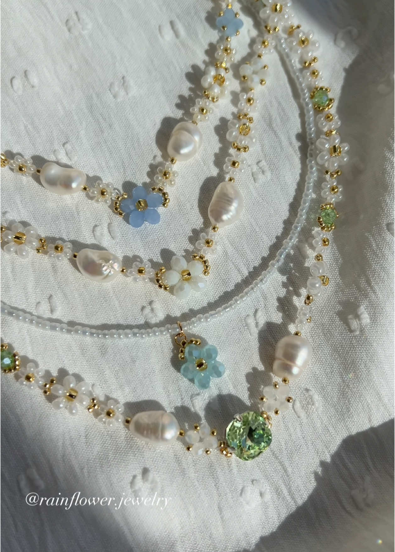A post by @rainflower.jewelry on TikTok caption: Stunning flower necklaces are now available in my shop with free worldwide shipping🤍💫 Let me know in the comments which one is your favorite🌱 #handmadevibes #daisynecklace #floralnecklace #aestheticjewelry #cutenecklace #floralstyle #jewelrytok #smallbusinessfinds 