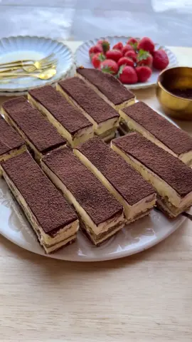 A post by @kookmutsjes on TikTok caption: TIRAMISU CHEESECAKE #food #recipe #cheesecake #tiramisu #tasty #foryou #dessert COOKIE DOUGH 100 g chocolate chip cookies 120 g tea biscuits 140 g unsalted butter CHEESECAKE BATTER 800 g cream cheese 125 g mascarpone 8 g vanilla sugar (or a teaspoon of vanilla extract) 140 g granulated sugar 45 g cornstarch 4 medium eggs FILLING 250 ml espresso ladyfingers TOPPING 125 g mascarpone 40 g powdered sugar 8 g whipped cream stabilizer (klopfix) 250 ml heavy cream GARNISH cocoa powder Melt the butter in a saucepan over low heat. Finely grind the chocolate chip cookies and tea biscuits in a food processor. Place the cookie mixture in a bowl and add the melted butter. Mix into a firm cookie dough. Spread the cookie dough over the bottom of a springform pan lined with parchment paper and press down firmly using the back of a spoon. Place in the refrigerator. In a large bowl, combine the cream cheese, mascarpone, vanilla sugar, and granulated sugar. Mix for 1 minute. Sift in the cornstarch and mix for another minute. Set the mixer aside. Crack the eggs and gently fold (one at a time) into the batter using a spatula. Pour half of the cheesecake batter over the cookie base and smooth it out. Briefly dip the ladyfingers into the cooled espresso. Arrange the ladyfingers on top of the batter. Add the remaining batter and smooth the top. Place the cheesecake in a preheated oven at 125 °C (257 °F). Bake for 60 minutes, or until the edges are set and the center still slightly jiggles. Turn off the oven and leave the cheesecake inside for 1 hour with the door closed. Then chill in the fridge for at least 4 hours (preferably overnight). Mix the mascarpone, powdered sugar, and whipped cream stabilizer for 1 minute until smooth. Gradually add the heavy cream and mix until thick and firm. Spread the cream evenly over the cheesecake. Just before serving, dust with a light layer of cocoa powder. Cut into equal pieces and serve. Tips: Use the back of a spoon or a glass to press the cookie base — this ensures that crust doesn’t crumble when sliced. If the espresso is still warm, the ladyfingers will become soggy and may affect the batter. Let it cool completely (or use cold espresso from the fridge). Don’t soak the ladyfingers too long! Half a second is enough to keep their structure and give that delicious tiramisu bite. Let the cream cheese, mascarpone, and eggs come to room temperature for smoother mixing and a lump-free batter. Use a spatula and fold gently to prevent the batter from becoming too runny or overly aerated (which can cause cracks). You can substitute vanilla sugar with vanilla extract. I used a 24 cm square springform pan.