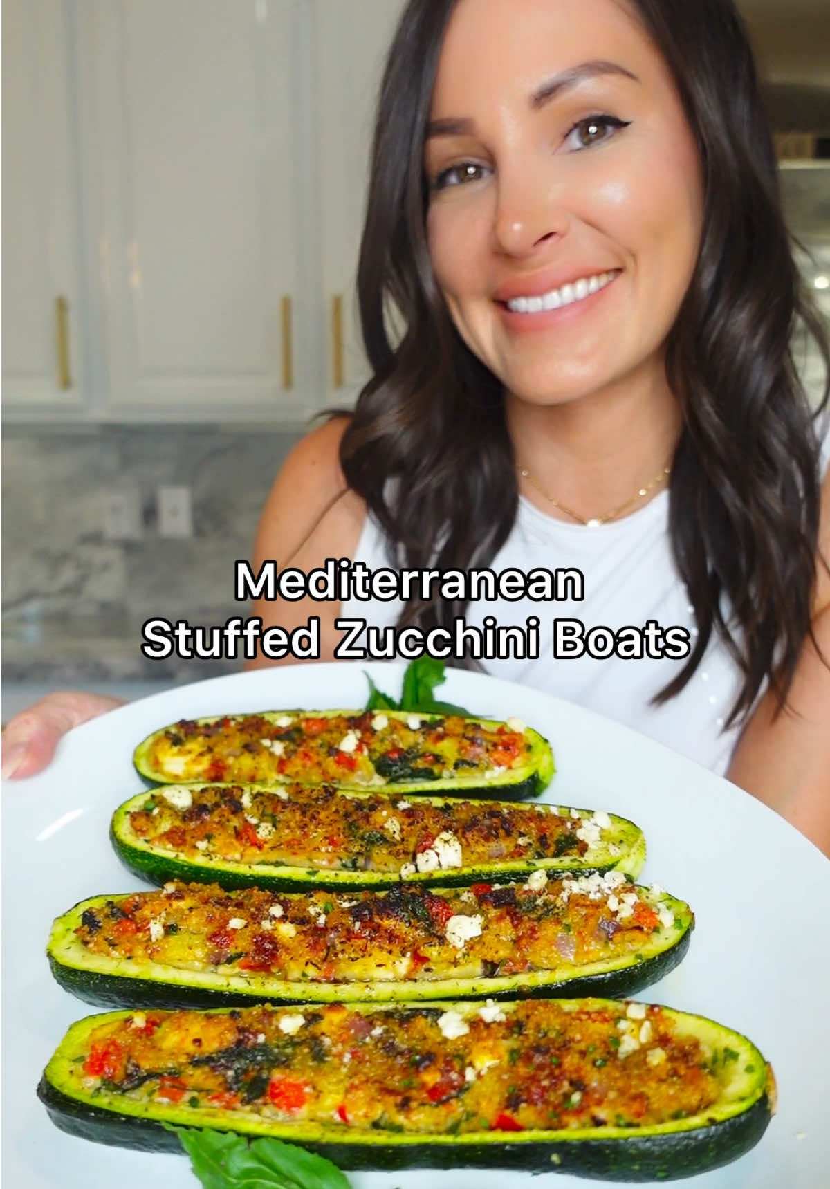 A post by @chefgenevieve on TikTok caption: Weeknight dinner just got a Mediterranean makeover! These easy stuffed zucchini boats are loaded with sun-dried tomatoes, feta, spinach, olives, and herbs for a nutritious, flavor-packed meal the whole family will love! Mediterranean Stuffed Zucchini Boats Serves 4 Ingredients: 4 zucchinis 1/2 red onion, diced 1 red bell pepper 1 tsp oregano  2 garlic cloves, minced 3 cups baby spinach, torn into bite size 1/2 cup jarred sun dried tomatoes, chopped 1 cup crumbled feta, + more for garnish 1 cup seasoned breadcrumbs + 1/4 cup topping 1/3 cup Kalamata olives, chopped 3 eggs Olive oil Salt and Pepper TT Parsley for garnish (optional) Directions: Slice zucchini in half lengthwise then use a spoon to carefully scoop out the center (reserve). Chop reserved zucchini flesh into bite-size pieces then sauté in 1 tbsp olive oil along with diced red onion and red bell peppers until softened and all moisture has evaporated (about 5 minutes).  Add oregano, fresh garlic and baby spinach and cook until fragrant (about 1 minute longer). Season with salt and pepper to taste.  Add to a bowl along with sun-dried tomatoes feta, breadcrumbs and kalamata olives.  Whisk eggs then add to the mixture.  Spray, both sides of your zucchini boats with olive oil, season then fill with your stuffing. Top with more breadcrumbs, spray with olive oil then bake in a 400° oven for 20 minutes. Garnish with more feta and fresh parsley. Enjoy! #ZucchiniBoats #EasyDinnerIdeas #HealthyRecipes #WeeknightDinner #MediterraneanEats