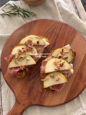 A post by @spanglishfashion on TikTok caption: Brie, pear & prosciutto Honey toast 🍐🍯 Ingredients for cheese:  - Brie Cheese ( 18 mins / Oven 350degrees)  - Honey - Rosemary - Pecan  - Dill Bread: - Olive oil - 1 Pear - Prosciutto - Honey - Pecan #toast #pear #brietoast #briecheese #homemade #cheeseandhoney