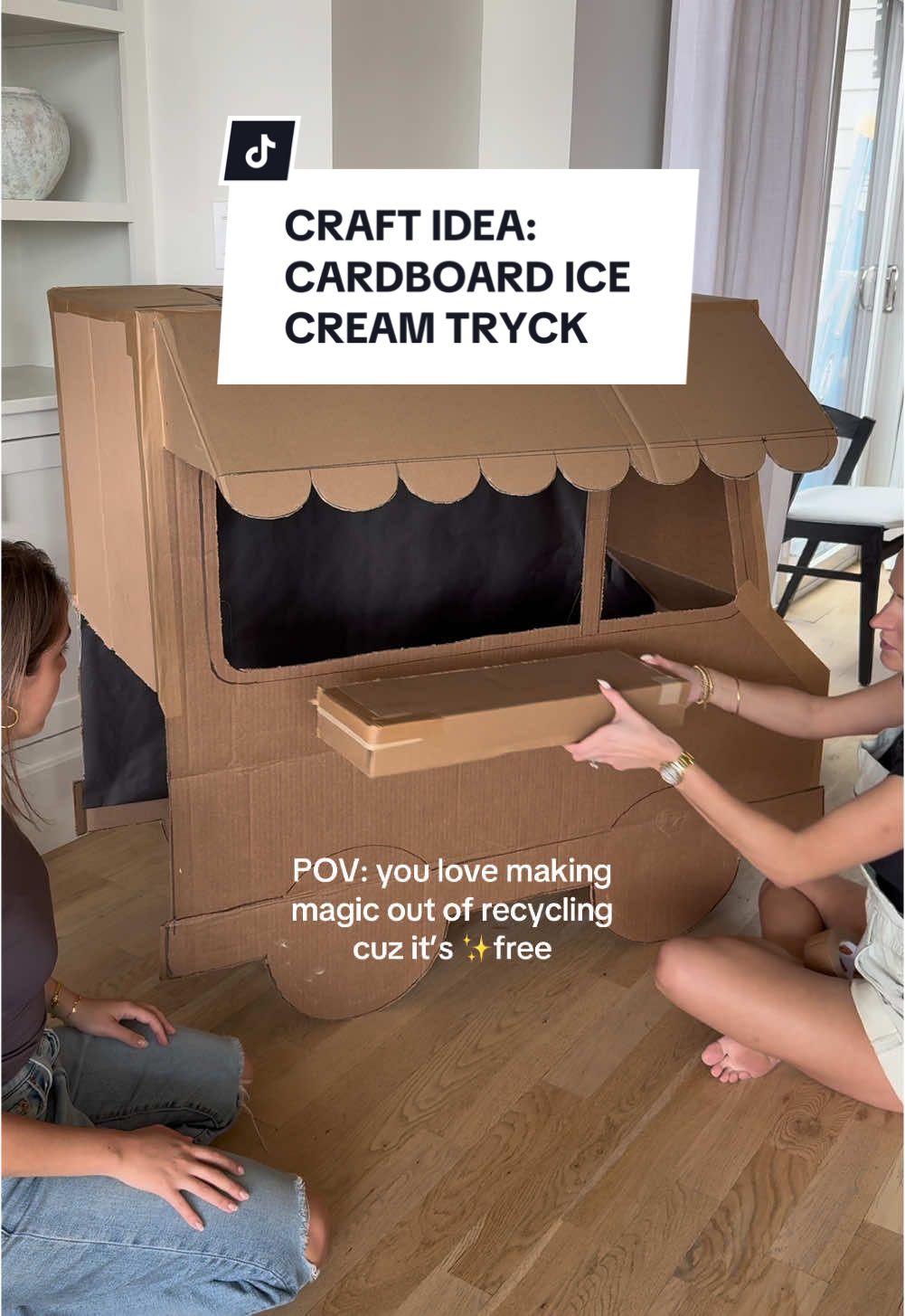 A post by @the_avantgarde on TikTok caption: Had this idea after looking at my pile of recycling, and omg it’s so cute 😭 setting up for our ice cream social next, do I add string lights over the table or too much!? #diy #cardboard #icecream #crafts 