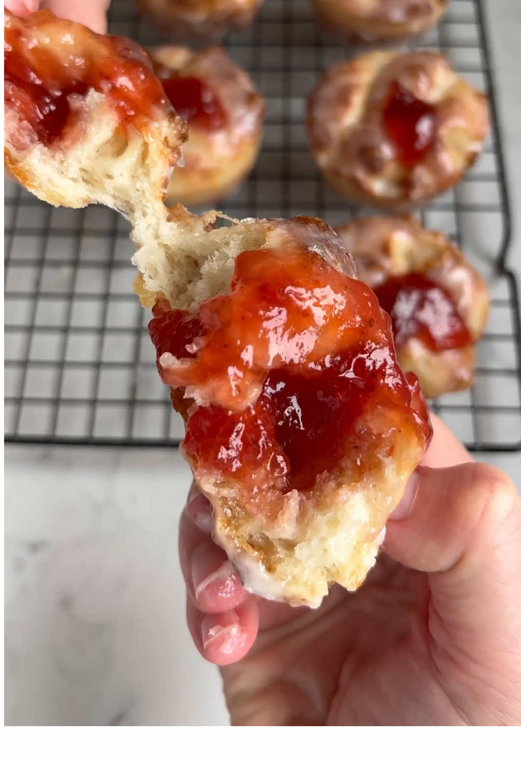 A post by @_lacebakes_ on TikTok caption: Mini Jam Donut Focaccias 🍓 if you love my jam donut focaccia recipe, here is a PSA that you can make it mini!  A batch of focaccia dough will yield 19 muffin sized focaccias… Ingredients: 1x batch same-day focaccia dough but add a tablespoon of sugar into the dough when mixing 6 tablespoons (90g) butter 1-1.5 cups (340g-510g) jam of your choice. Make sure it’s fairly smooth so easy to pipe.  (Quantity depends on how much jam you like piped in).  For glaze: 2 cups (250g) confectioners sugar 4 tablespoons milk (plus more if needed)  1/2 teaspoon vanilla extract 🍓 Mix up the dough and perform the stretch & folds as normal (same-day recipe is the first post at the top of my page). 🍓 after proofing in the bowl, divide into 50g dough balls on an oiled or buttered work surface. There should be about 19 pieces. 🍓 place each dough ball into a liberally buttered muffin tin (I use salted butter but you can also use unsalted butter, coconut oil, avocado oil or another neutral oil). 🍓 cover tin and proof for about an hour. They should have risen to nearly the top of the tin. Drizzle the tops of the dough with the remaining butter and dimple each of them. 🍓 bake at 220C/430F for 14-18 minutes on lowest rack until golden. If baking two trays at a time, bake one on bottom and one in middle and rotate mid way through the bake.  🍓 while baking, whisk together the ingredients for the glaze (adjust with more milk if needed). 🍓once baked, jab a fork into the side of the muffin and dunk into the glaze on both sides. Really shake off the excess glaze and then place onto cooling rack. 🍓 transfer jam into a piping bag or zip top bag with the corner snipped off. When glaze has hardened, jab a hole into the middle of each (I use a plastic straw), swirl it around to create a hole in the muffin and pipe the jam in - fill as generously as you wish to. Enjoy!  You will need two muffin tins if you plan to make them all into jam donuts. Another idea is to only use one muffin tin, make 12 and turn the remaining dough into a small Sicilian style focaccia pizza (that’s what I did!). And no the dough wasn’t too sweet for pizza with the added sugar in the dough.The quantities stated here are for a full batch of 19 donuts, so scale down glaze/jam if making fewer.  See comments for more tips!  #focaccia #jamdonutfocaccia #jamdonut #jellydonutfocaccia #jellydonut #breadtok #bakingtok 