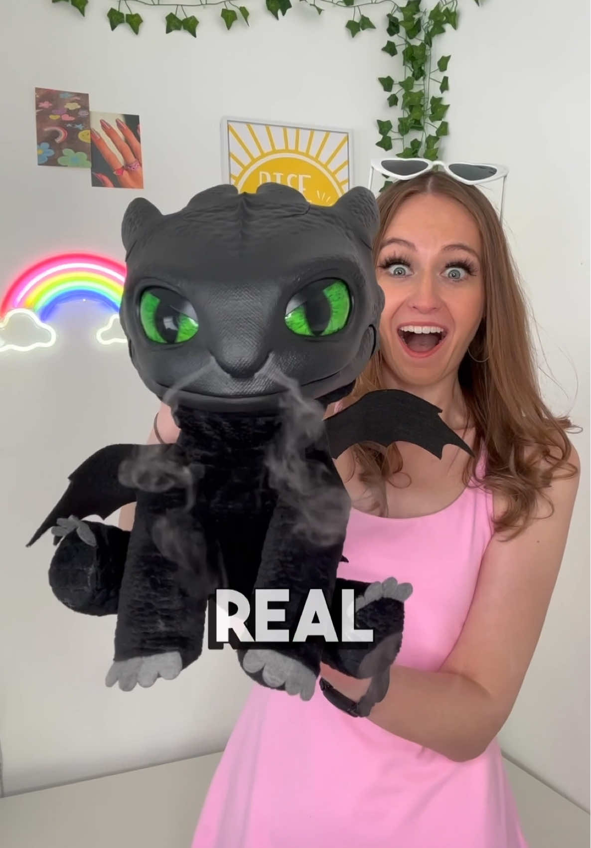 A post by @rhia.official on TikTok caption: #AD Give a ROARING welcome to the NEW Toothless Puppetronic by RealFX!🥳🐲✨ With over 50 action and sound combinations, you can REALLY ‘Train your Dragon’ Toothless!😱 Just watch out for his PLASMA BLAST!🤩💥Available now at @Smyths Toys Superstores #toothlesspuppetronic #puppetronic #realfxtoothless #howtotrainyourdragon #SmythsToys #HTTYDToys @wowstuffofficial @httydragon 