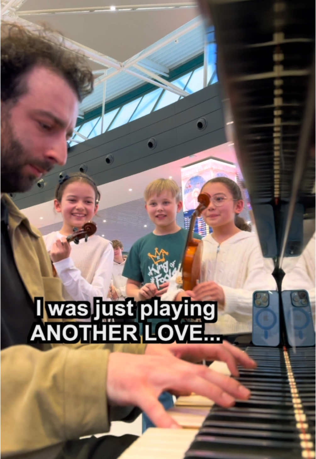 A post by @juliencohen_piano on TikTok caption: I was playing ANOTHER LOVE when 3 little kids came up to me and asked to play… the whole airport was shocked by how good they are! Singer is @BJARNE_OFFICIAL  Violinists: sora_clea_violin on instagram.  In @Rome Airports  #anotherlove #tomodell 