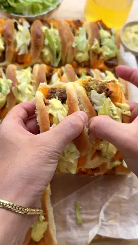 A post by @kookmutsjes on TikTok caption: BIG MAC PARTY BUNS #food #recipe #bigmac #party #buns #beef #tasty #foryou #fyp DOUGH 225 ml lukewarm milk 7 g instant yeast (1 tablespoon) 15 g honey 1 medium egg 35 ml sunflower oil 450 g flour (all-purpose flour) 8 g salt (1⅓ teaspoon) BEEF MIXTURE 25 ml sunflower oil 500 g ground beef 3 g salt (½ teaspoon) 1.5 g black pepper (½ teaspoon) 50 g cheddar cheese SAUCE 175 g mayonnaise 40 g mustard 50 g pickles (±2, finely chopped or grated) 10 g yellow onion (grated) GARNISH cheddar cheese lettuce INSTRUCTIONS Add the lukewarm milk, yeast, and honey to a large bowl. Mix well and let it rest for 5 minutes. Add the beaten egg and sunflower oil. Mix well. Then add the flour and salt. Knead for 10–12 minutes until smooth. Cover and let the dough rise for 1 hour, or until it has doubled in size. Heat the sunflower oil in a skillet over medium heat. Add the ground beef, salt, and black pepper. Cook the beef until browned and crumbly, about 7–8 minutes. Add the cheddar cheese to the meat and stir until the cheese has melted and the mixture thickens slightly. Set aside and let cool a bit. In a separate bowl, mix the mayonnaise, mustard, grated pickles, and grated onion into a smooth sauce. Set aside. Deflate the dough and divide it into 20 equal portions (about 35 grams each). Shape into balls. Roll each ball into a circle of about 9 cm in diameter. In the center, place half a slice of cheddar cheese, a small spoon of sauce, and a spoonful of the beef mixture. Fold the edges of the dough inwards to enclose the filling. Place the filled dough on a parchment-lined tray. Let it rise again for 30 minutes, until doubled in size. Preheat the oven to 200 °C (390 °F). Bake the rolls for 15–25 minutes until golden brown and cooked  through. Every oven is different, so keep an eye on the baking time. Carefully remove the rolls from the oven and top with a bit of cheddar cheese. Garnish the warm rolls with extra sauce and finely shredded iceberg lettuce.