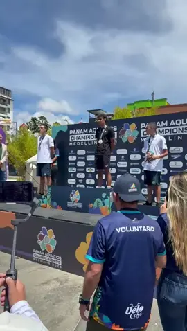 A post by @com_mexico on TikTok caption: Suena el himno nacional con la medalla de oro de Paulo Strehlke en la competencia de 10km en Aguas Abiertas del Primer Campeonato Panamericano de Deportes Acuáticos.