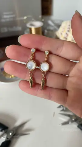 A post by @likayjewel_diylilylin on TikTok caption: Bubble fish earrings 🐟✨🩵🫧#handmadejewelry #tutorial #wirewrapping #wirewrappedjewelry #earrings #dropearrings #handmadeearrings #summerjewelry #jewellery #foru 