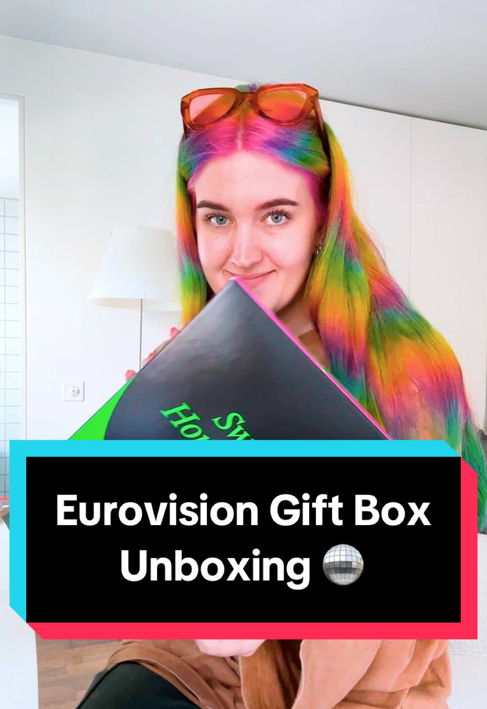A post by @kellylouisekilljoy on TikTok caption: A full video of me unboxing Swiss things, not knowing what anything is 🇨🇭🪩 #eurovision2025 #switzerland #unboxing #giftbox 