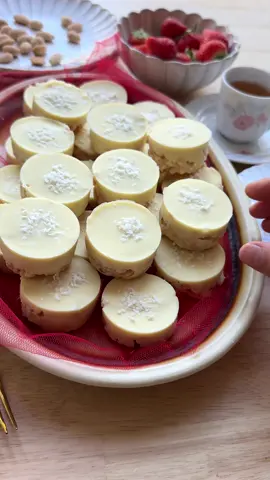 A post by @kookmutsjes on TikTok caption: CRUNCHY CHOCOLATE BITES (NO BAKE) #food #recipe #chocolate #whitechocolate #crunchy #nobake #cookies BASE 250 g white chocolate 50 g cornflakes 15 g grated coconut GANACHE 40 g heavy cream 100 g white chocolate FILLING roasted almonds TOPPING 200 g white chocolate grated coconut Melt the white chocolate (250 g) using a double boiler (au bain-marie). Place the melted chocolate in a deep bowl. Add the cornflakes and grated coconut (15 g). Mix well. Heat the heavy cream (40 g) in a small saucepan almost to a boil. Remove it from the heat and add the chopped white chocolate (100 g). Let it sit for 1 minute, then stir until smooth. Transfer the ganache to a piping bag. Take a silicone mold. Spread a layer of the cornflake mixture into the bottom and press down firmly. Pipe a layer of ganache over the mixture and place a roasted almond on top. Cover with another layer of the cornflake mixture and smooth the surface. Cover and refrigerate for 4–5 hours, preferably overnight, to set. Melt the white chocolate (200 g) using a double boiler. Transfer to a piping bag. Pipe a layer of melted chocolate on top of each mold and sprinkle with grated coconut. Let the chocolate fully harden.