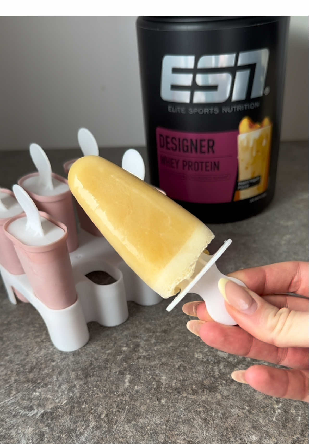 A post by @esncom on TikTok caption: Designer Whey Peach Yogurt kommt morgen endlich zurück! 🍑🥤 #esn #designerwhey #peachyogurt 
