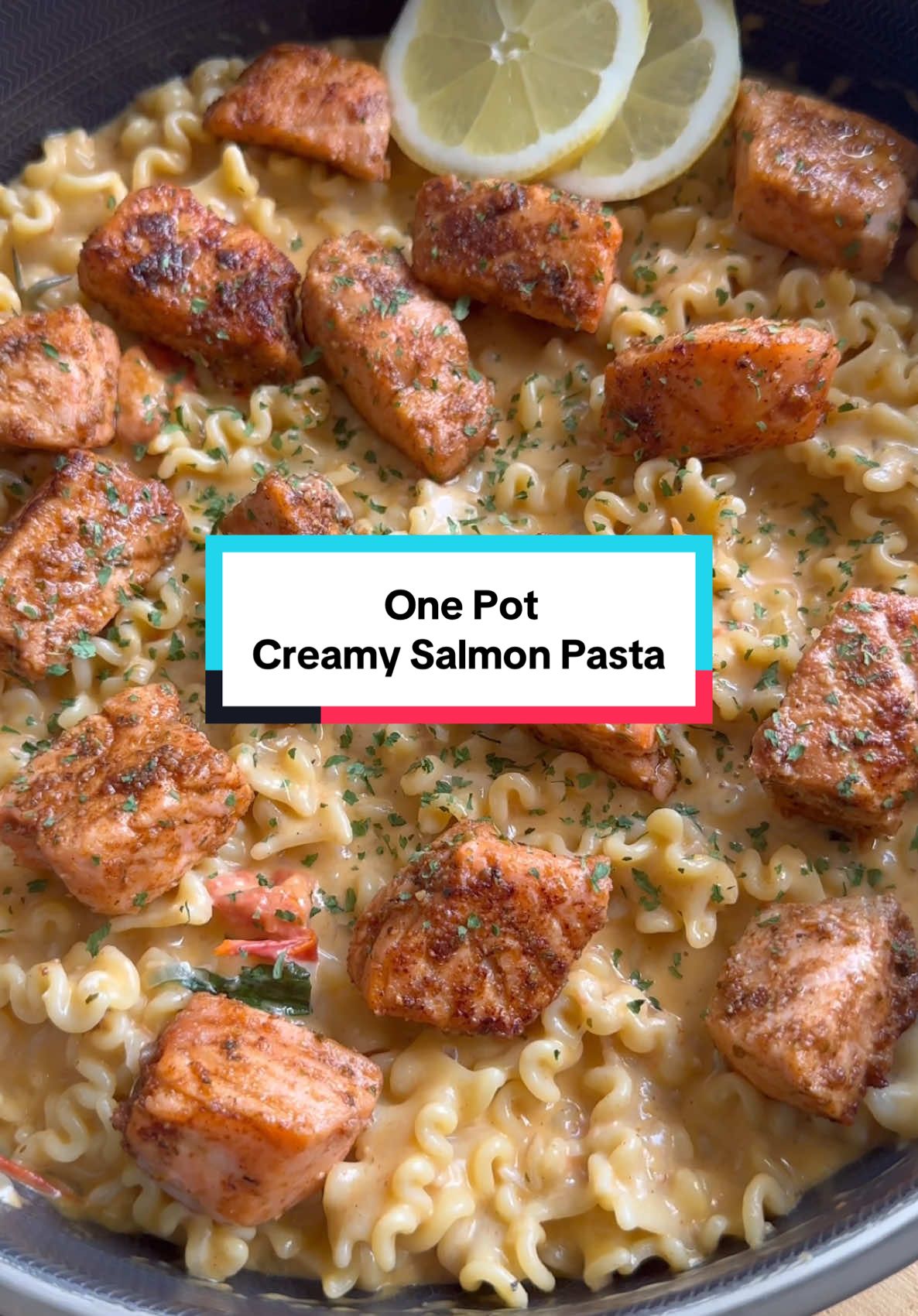 A post by @kauscooks on TikTok caption: One Pot Creamy Salmon Pasta Recipe [AD] This summer I’m giving my everyday favourites a little upgrade with @Sainsbury’s Taste The Difference range, the quality of these ingredients is amazing - the lightly smoked salmon is honestly SO flaky and soft, you need to try it for this one pot salmon pasta! Serves 4 Ingredients Salmon Bites * 4 salmon fillets, cut into bite-sized chunks  * 1 tsp paprika * ½ tsp hot cayenne pepper * 1 tsp oregano * 1 tsp garlic powder * 1 tsp onion powder * ¼ tsp pepper * ½ tsp salt * 3 tbsp oil Pasta Sauce * 2 shallots * 5 garlic cloves, minced * 250g cherry vine tomatoes * 10–12 fresh basil leaves * Zest of ½ lemon * 1 tsp paprika * ½ tsp hot cayenne pepper * 1 tsp oregano * 1 tsp onion powder * ¼ tsp pepper * A pinch of salt, to taste * 750ml vegetable stock * 150ml double cream * 4 tbsp grated Parmigiano Reggiano * 400g Mafalda Corta pasta (dry weight)   Method 1. In a bowl, toss the salmon chunks with all the listed salmon seasonings and 1 tbsp of oil until well coated. 2. Heat the remaining 2 tbsp oil in a large pan over medium heat. Add the salmon pieces and cook for about 3 minutes on each side until golden and just cooked through. Remove and set aside. 3. In the same pan, add the diced shallot and garlic. Cook over medium heat for 2-3 minutes until softened. 4. Add the remaining pasta sauce seasonings, lemon zest, cherry tomatoes, and basil. Cook for 2–3 minutes until the tomatoes begin to soften. 5. Pour in the vegetable stock and stir in the pasta. Mix well, cover with a lid, and simmer on low heat for 15-20 minutes until al dente, stirring every 10 minutes to prevent sticking. Add a splash of water if more need. 6. Once the pasta is cooked, add the double cream, grated Parmigiano Reggiano, and some extra fresh basil. Stir until the sauce is creamy and well combined. 7. Serve the pasta topped with the golden salmon bites and enjoy. #onepotrecipe #pastarecipe #salmon