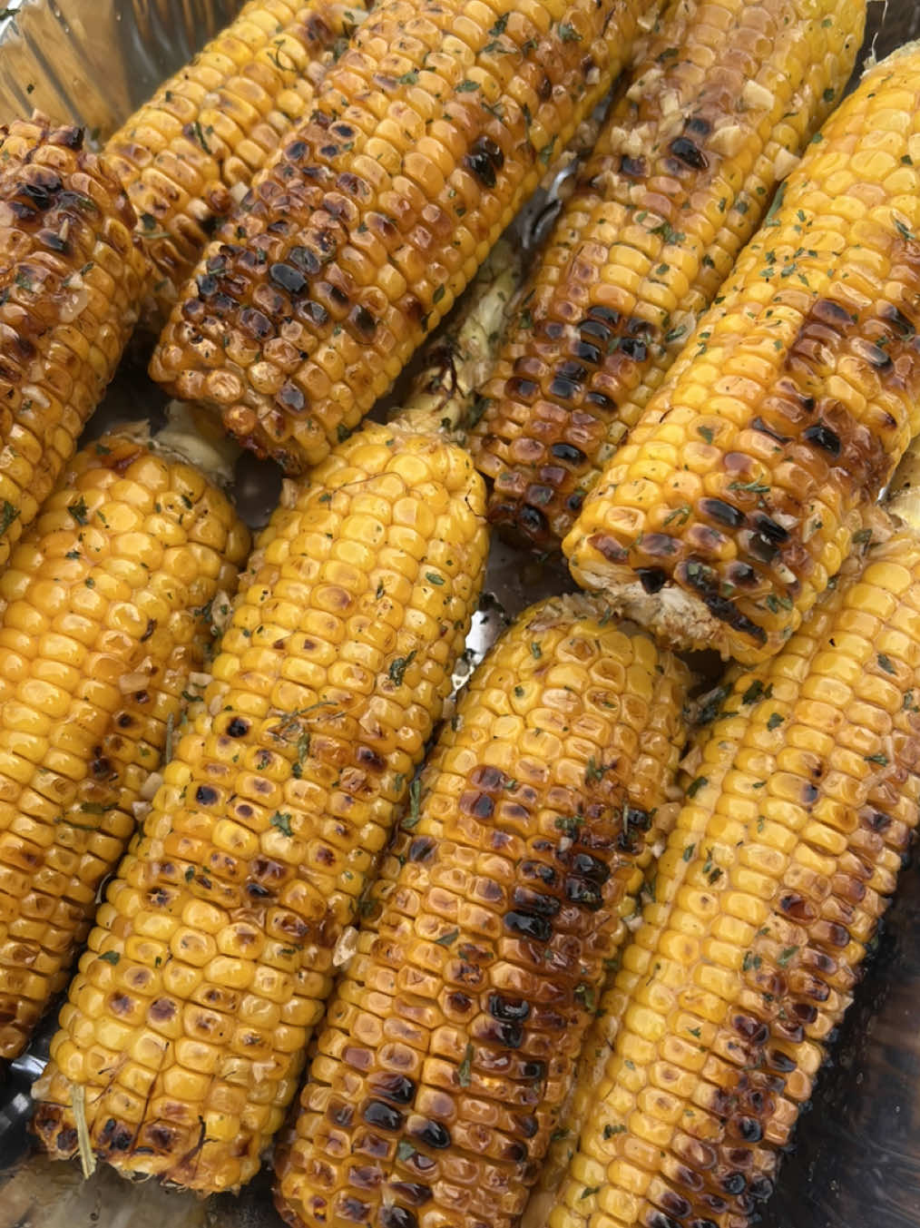 A post by @britscookin on TikTok caption: Cajun Honey Butter Corn 🌽🔥This one is perfect for your 4th of July cookout or any summer BBQ! 🇺🇸 You’ll need: 	•	10-12 ears of corn, shucked (leave the stems on if you can) 	•	½ cup butter 	•	2 tbsp minced garlic 	•	2 tbsp honey 	•	2 tsp Cajun seasoning (I used my Britscookin blend) 	•	A couple dashes of mild jalapeño hot sauce Instructions: 	1.	Grill corn over hot coals for 10–15 minutes, turning every few minutes to get a good char. 	2.	In a cast-iron skillet on the grill, melt together the butter, garlic, honey, Cajun seasoning, and hot sauce. 	3.	Brush the butter mixture all over the corn as it grills. Keep flipping and basting until the corn is tender and golden. 	4.	Serve it up hot—we had it with steak, smashed potatoes, and fresh veggies from the garden. Brush the remaining butter on some grilled bread! YUM #easyrecipe #grilling #4thofjuly  #creatorsearchinsights 