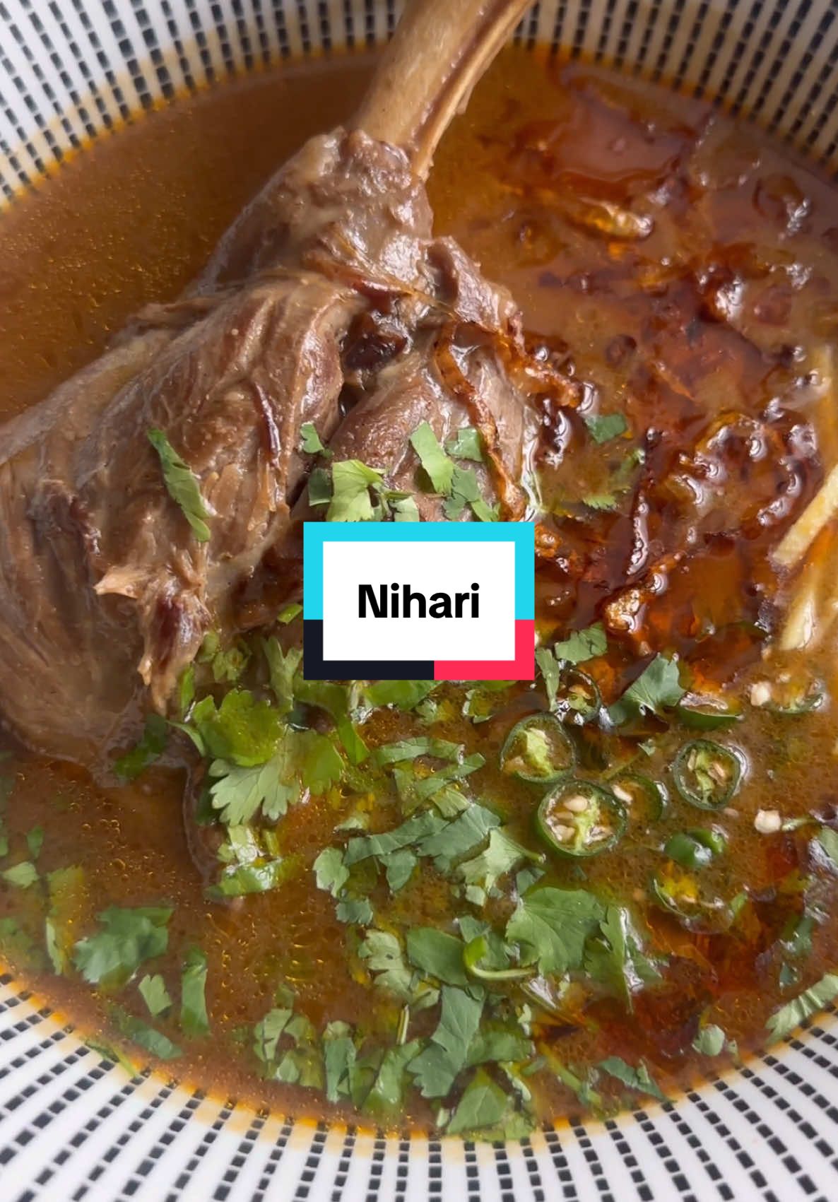 A post by @kauscooks on TikTok caption: EID SPECIAL: Lamb Nihari Recipe Nihari is considered the national dish of Pakistan and is traditionally enjoyed for breakfast, especially on weekends or on Eid mornings. Rich, deeply spiced, and slow-cooked to perfection, it’s one of the most indulgent and flavour-packed curries you'll ever taste. A true labour of love. For the Nihari Spice Mix: * 1 tbsp whole cumin * 1 tbsp whole coriander seeds * 1 tbsp caraway seeds (shah jeera) * ½ tbsp fennel seeds (saunf) * ½ tbsp black peppercorns * 4 cloves * 8 green cardamoms * 2 black cardamoms * 4 bay leaves * 2 star anise * ½ tsp nutmeg * ½ tsp mace powder or 1 mace blade (javitri) * 2-inch cinnamon stick For stewing the meat: * 2kg lamb shanks * 4 tbsp ghee * 2 tbsp oil * 1 large onion * 1 tbsp garlic paste * 1 tbsp ginger paste * 1½ tsp salt, or to taste * 1 tbsp Kashmiri red chilli powder * ½ tbsp ginger powder * 1 tsp turmeric powder * Approx. 1.5 litres water * Slurry: 1 cup whole wheat flour (atta) mixed with 2 cups water For the tarka: * 3 tbsp ghee * 1 large onion, finely sliced * 1 tbsp paprika or Kashmiri red chilli powder To serve: * Julienned ginger * Fresh coriander * Lemon slices * Chopped green chillies Method: 1. Heat ghee and oil in a large pot. Sear lamb shanks on high heat for 5–6 minutes until browned. Add onion, garlic paste, and ginger paste; cook for 3-4 minutes. 2. Toast the whole spices for 2 minutes until fragrant, then grind to a fine powder. 3. Add the spice mix and remaining dry spices to the pot. Cook for 3-4 minutes to coat the meat. Pour in water and bring to a boil. Cover and simmer on low for 3 hours, or pressure cook for 30–35 minutes, until the meat is tender. Remove the meat and set aside. 4. Dry-roast atta (optional, or use as it is), mix with water to form a slurry, and stir into the pot, mix well. Optional: strain for a smoother sauce. 5. Return the meat and simmer for 15–20 minutes until the gravy thickens. Adjust slurry as needed for desired consistency. 6. For Tarka: melt ghee, brown onions for 5-6 minutes, add chilli or paprika and let it sizzle for 1 minute then add into Nihari, mix well and serve. #nihari #eiduladha 