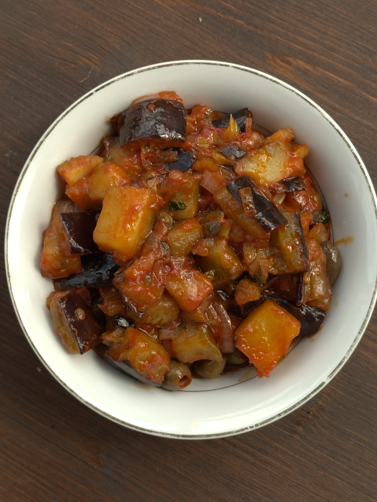 A post by @giallolovesitaly on TikTok caption: Sweet, tangy, and savory: this Sicilian Caponata brings all the Mediterranean vibes to your table🍆🌿 Perfect as a side dish or appetizer!🥰❤️ @mattiastable Ingredients: 2 eggplants Salt, to taste Extra virgin olive oil, to taste 1 onion, chopped 1 stalk of celery, chopped 1 tablespoon tomato paste 2 tablespoons green olives 1/4 cup vinegar (4 tablespoons / 60 ml) 1 tablespoon sugar 2 tablespoons capers (a handful) #giallolovesitaly #caponata #eggplant #foodtok