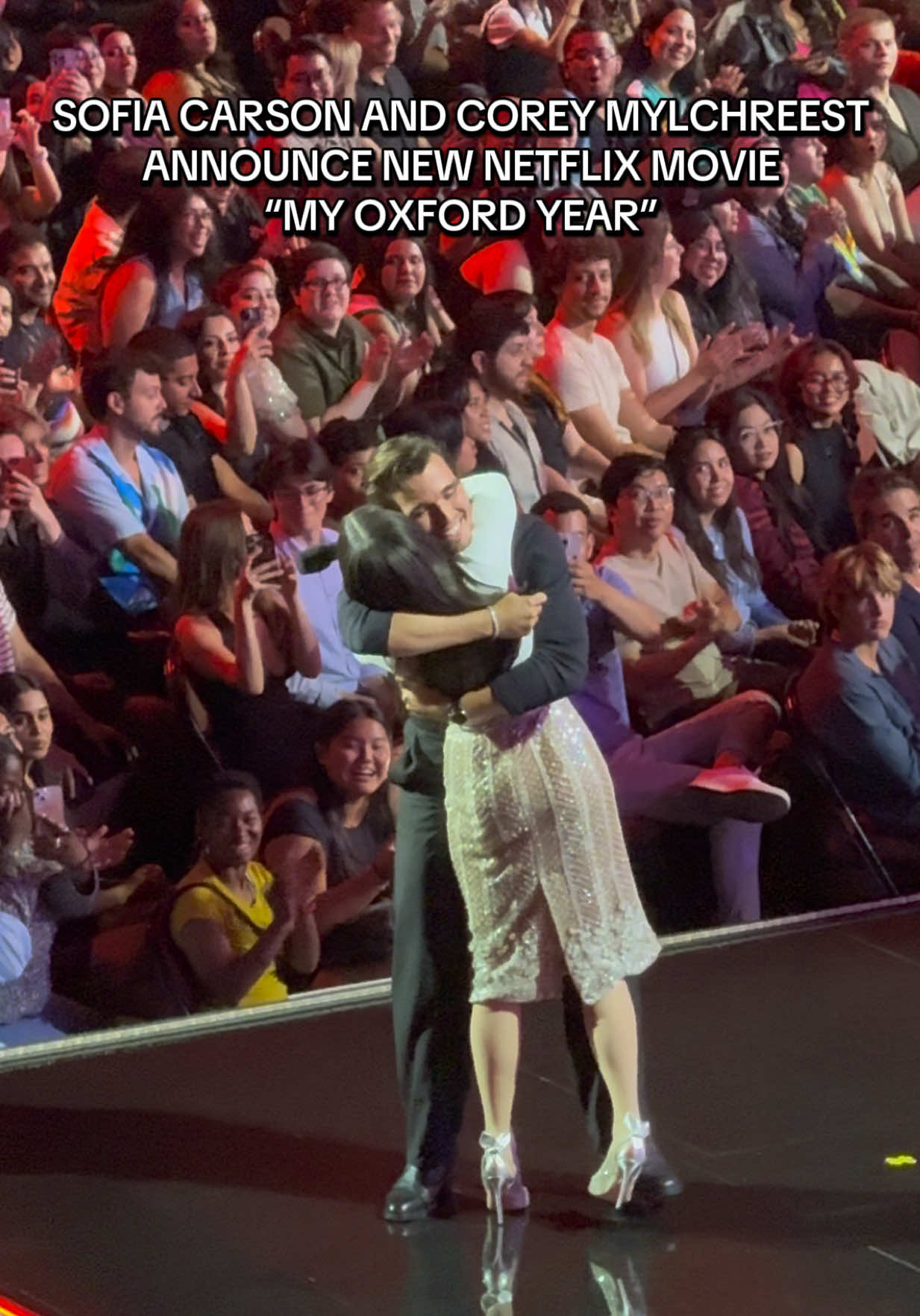 A post by @ashtongaler on TikTok caption: Sofia Carson and Corey Mylchreest announce new Netflix movie called “My Oxford Year” coming August 1st @SofiaCarson #sofiacarson #coreymylchreest #myoxfordyear #netflix #tudum #losangeles #kiaforum 