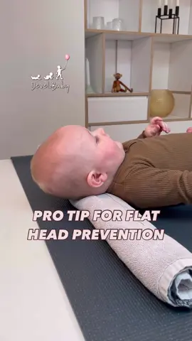 A post by @develobaby on TikTok caption: If your baby has a flat spot on the back of their head, here’s an easy method to help! 🍼✨ Roll up a small towel or blanket and gently place it under your baby’s neck while they are awake and supervised. This helps relieve pressure from the back of their skull and encourages head movement in all directions. 👶 ⚠️ Important: Never use this method during naps or bedtime when your baby is unsupervised. Safety first! This tip is a part of my program “Back Arching and Flat Head” which contains all the best practice exercises and positioning tips according to Danish Health Standards. Go to bio for link! With love, Maria ♥️ #FlatHeadPrevention #BabyTips #TummyTime #ParentingTips #BabyDevelopment