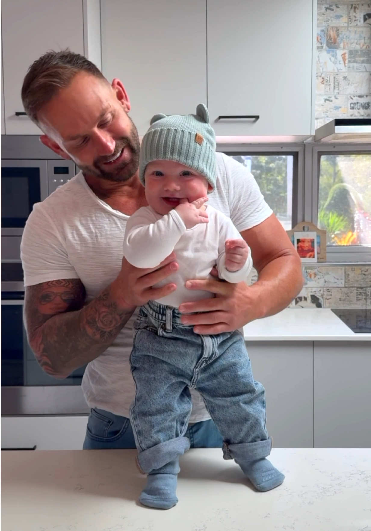 A post by @joelbushby on TikTok caption: It’s bottle o’clock 🍼🕺🏻 Might be best if I leave the dancing to my son from now on 😅 #BlueShirtGuy 