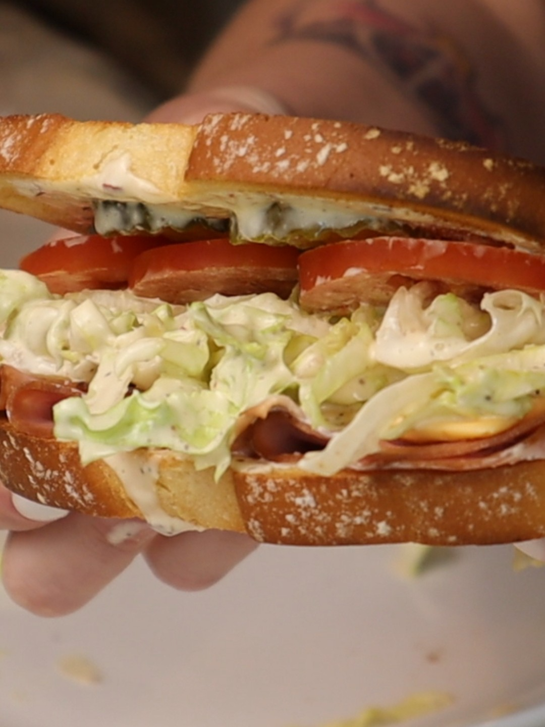 A post by @dollartreedinners on TikTok caption: We call this “the fancy sandwich” and it’s one of our favorite summer meals. It’s not a recipe—it’s a vibe. Inspired by the viral Italian grinder but made with whatever we have on hand. Here’s how I make it: Dressing: – Big scoop of mayo – Spoonful of Dijon mustard – Splash of pickle juice or banana pepper brine – Salt, pepper, garlic powder, onion powder, red pepper flakes Stir until creamy and well seasoned. Taste and adjust. Slaw: Toss shredded iceberg lettuce in the dressing. Let it sit a few minutes if you can. Assembly: – Lightly toasted bread – Deli meat (ham today) – A slice of cheese – That dressed-up slaw – Sliced tomato and pickles Crunchy, salty, tangy, and always hits the spot. #thefancysandwich #grindersandwich #easyrecipes #summermeals #noreciperecipe #budgetfriendlymeals #dinnerideas #sandwichseason #pantrymeals #homemadesandwich #refrigeratorcleanout #usewhatyouhave #simplemeals #lunchideas #notarecipeitsavibe