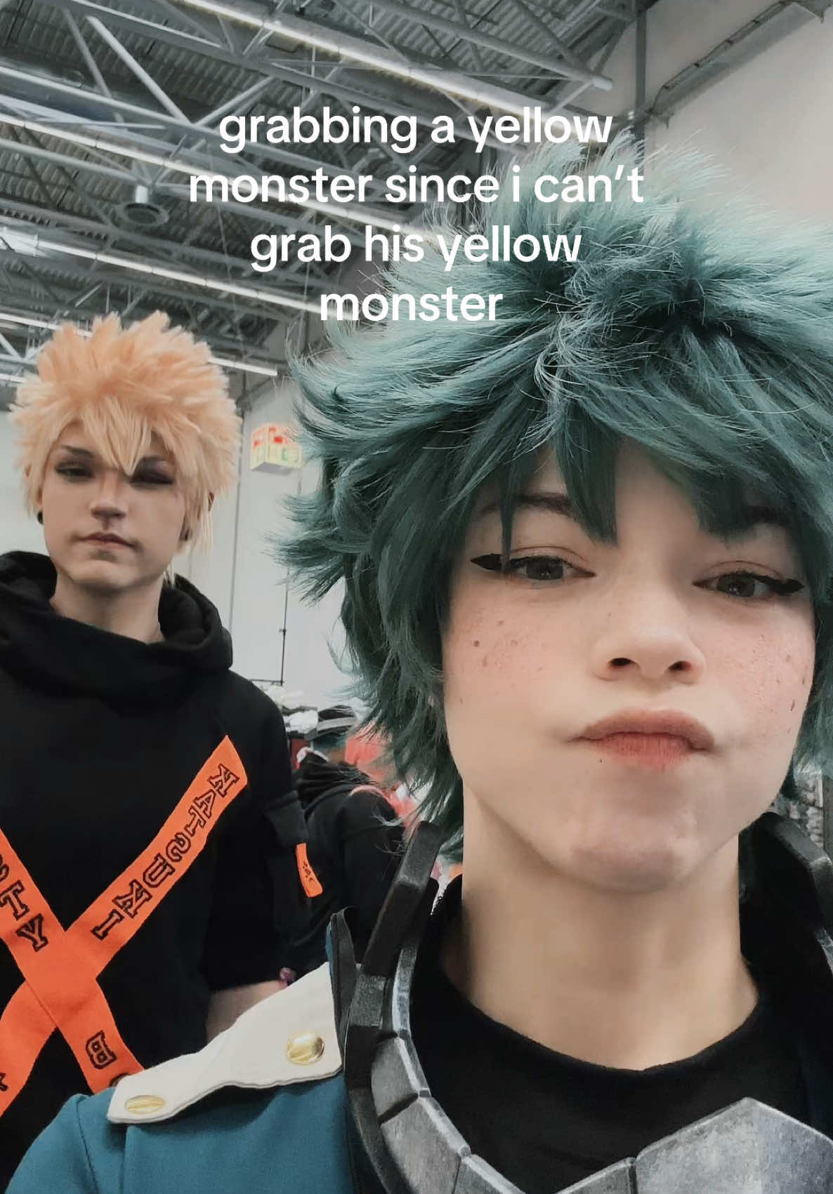 A post by @teacakecos on TikTok caption: last day at #dokomi 🧡💚  @Lena_Kuroi / レナくろい #dokomi2025 #germancosplayer #deku #bakugou #dekucosplay #mhacosplay #bnhacosplay #bakudeku 