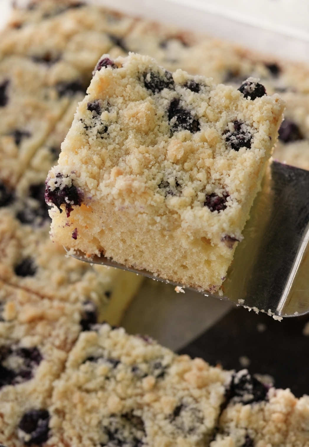 A post by @nefisyemektarifleri on TikTok caption: Yaban Mersinli Kek | Blueberry Crumble Cake 🫐🍰 İçi yaban mersinli, üst katmanı kırıntı hamurlu nefis mi nefis bir kek hazırladık sizlere! Kaydetmeden geçmeyin! 😉 ENGLISH BELOW 👇🏻 Malzemeler 3 yumurta 1 su bardağı şeker 1 su bardağı yoğurt 1 su bardağından bir parmak eksik sıvı yağ (180 ml) 1 limon kabuğu rendesi 2,5 su bardağı un 1 paket vanilya 1 paket kabartma tozu 1 su bardağı yaban mersini  Crumble hamuru İçin; 2 yemek kaşığı tereyağı 2 yemek kaşığı şeker 4 yemek kaşığı un Hazırlanışı Yumurta ve şekeri beyazlaşıp köpük köpük oluncaya kadar 5 dakika çırpalım. Yoğurt, sıvı yağ ve limon kabuğu rendesini de ekleyip çırpmaya devam edelim. Un, vanilya ve kabartma tozunu da ekleyip son kez çırpalım. Hamurun kıvamı biraz koyu olacaktır. Diğer taraftan tereyağı, toz şeker ve unu bir kapta elimizle kırıntı haline gelinceye kadar ufalayalım. Eğer hamurlaşırsa biraz daha un ilavesi yapabilirsiniz. Yağlayıp unladığımız bir borcama kek hamurunu aktaralım ve eşit bir şekilde yayalım. Hamurun üzerine yaban mersinlerini yerleştirelim. Ufaladığımız hamurları da üzerlerine serpiştirelim. Önceden ısıttığımız 180 °C fansız ayardaki fırında 40 dakika pişirelim. Keki fırından aldıktan sonra mutlaka oda sıcaklığına gelinceye kadar dinlendirelim.  Dilediğimiz şekilde dilimleyerek servis edelim. Afiyet olsun! . You'll need For the cake: 3 eggs 1 cup sugar 1 cup yogurt 180 ml vegetable oil  Zest of 1 lemon 2½ cups flour 2 tsp vanilla sugar 2 tsp baking powder 1 cup blueberries For the crumble topping: 2 tbsp butter 2 tbsp sugar 4 tbsp flour 1 cup = 200 ml Here's how Beat the eggs and sugar until light and fluffy (about 5 minutes). Add yogurt, oil, and lemon zest. Mix well. Sift in flour, vanilla sugar, and baking powder. Stir to form a thick batter. In a separate bowl, mix butter, sugar, and flour by hand until crumbly. If too doughy, add a bit more flour. Pour the batter into a greased and floured baking dish. Scatter blueberries on top, then sprinkle the crumble mixture over them. Bake in a preheated oven at 180°C (356°F) for 40 minutes (no fan). Let cool completely before slicing and serving. Enjoy! #nefisyemektarifleri #kektarifleri #kek #recipes #cake #tiktokmutfağı