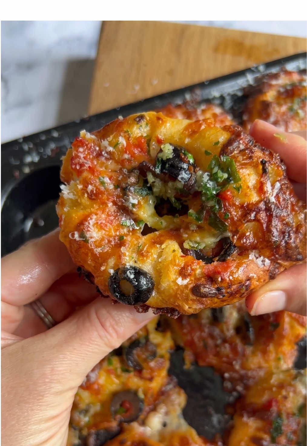 A post by @_lacebakes_ on TikTok caption: Stuffed Focaccia Pizza Muffins - makes 19 I used my same-day focaccia dough for these ones but you can also use my overnight or sourdough focaccia doughs (click FOCACCIA TUTORIALS playlist button above my grid to see them all).  1. Prepare focaccia dough according to recipe instructions up until the point where it's time to transfer to baking tray 2. Prepare muffin tin with olive oil or butter (I’ve found that the muffins stick less if you use butter) 3. portion 50g focaccia dough in each compartment (about 19 portions per batch of dough)  4. Cover with inverted tray and let proof at room temperature for 1-1.5 hours 5. Prepare pizza toppings and garlic butter (I simmer 2 Tbsp extra virgin olive oil, 2 Tbsp butter and 5 cloves minced garlic for 2 mins and then add in chopped parsley). Reserve some garlic butter for brushing over tops after they’re baked.  6. Preheat oven to 215/420F with large baking tray placed on lowest rack (to catch any oil spilling over).  7. Spoon garlic butter over each and dimple dough using two oiled fingers (dimple 3-4 times for each compartment)  8. Add generous spoonful of pizza sauce to each  9. Add on a few pizza toppings, some grated mozzarella cheese, more toppings and then dimple all of the toppings into the dough. Sprinkle some extra mozzarella over each muffin.  10. Bake for 16-20 minutes until cheese is golden brown and toppings are crisping up. If cheese is starting to brown too much before the bottoms are crisp, then just tent some foil over the top for a few extra minutes. If baking two muffin tins at a time, do one on the middle rack and swap the tray positions midway through the bake.  11. Once the mini focaccia pizzas are out of the oven, brush on additional garlic butter and a sprinkle of freshly Parmesan to finish  12. You may need to pry out of tin with a knife, the baked cheese will stick to the tin!  #focaccia #focacciatutorial #bread #breadrecipe #breadlover #asmr #asmrfood #asmrcommunity #cheese #foodporn #cheesepull #Pizza