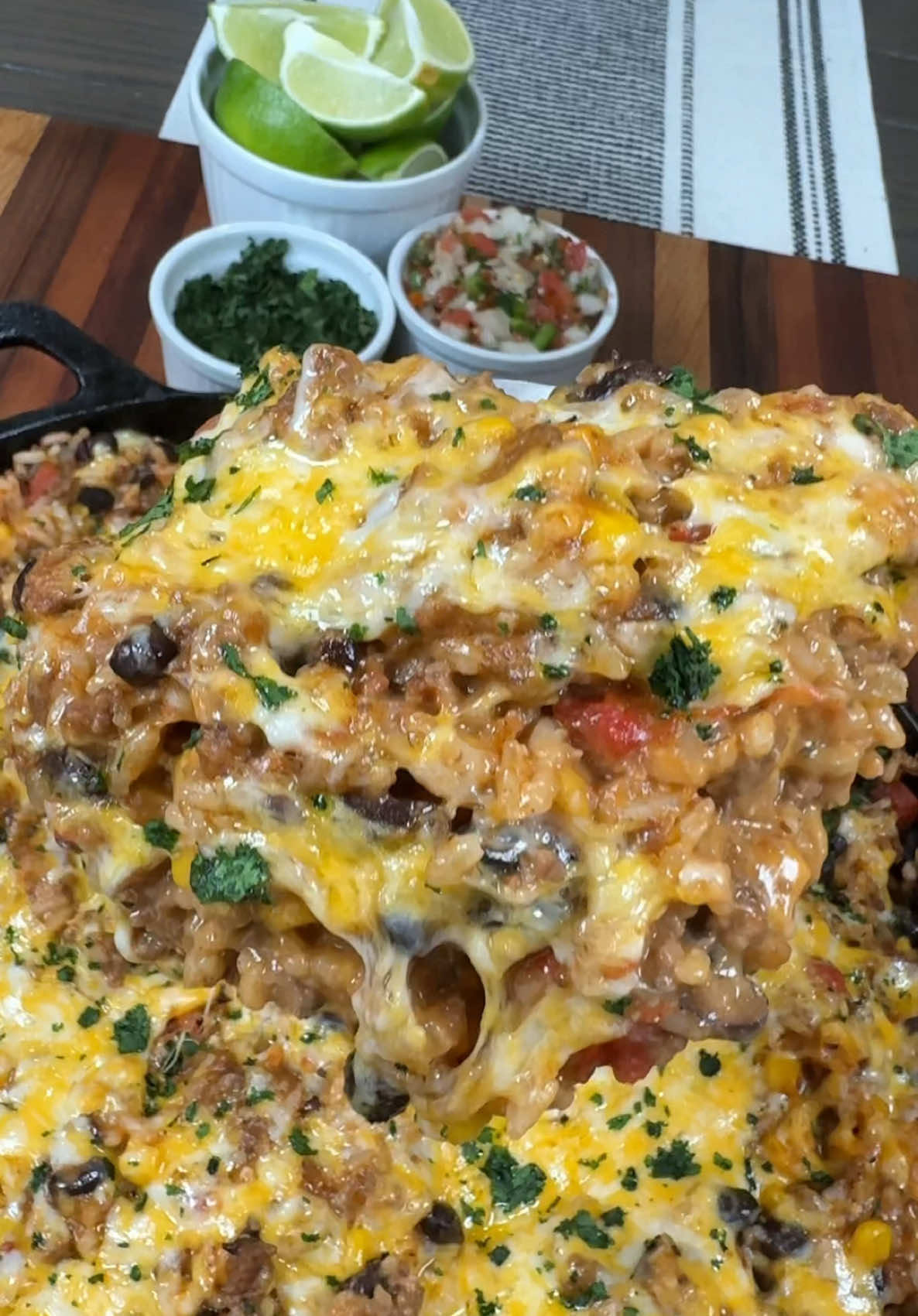 A post by @cookinginthemidwest on TikTok caption: Cheesy Fiesta Taco Rice is an easy one pan dinner!  INGREDIENTS 1 lb of ground beef  1/2 tsp each salt and pepper 2 tsp chili powder 1 tsp each of cumin and dried cilantro 1 onion, chopped  1 tbsp minced garlic  10 oz can of Rotel, not drained 8 oz can of tomato sauce  10 oz can of corn, drained  10 oz can of black beans, drained and rinsed  1 1/2 cups of chicken OR beef broth 1 cup of long grain white rice, uncooked & rinsed  2 cups of shredded Colby Jack cheese  Sour cream  Cilantro  Pico de gallo  Taco sauce  INSTRUCTIONS.  Brown 1 lb of ground beef in a skillet over medium-high heat, add all seasonings, and the onion.  Let that cook until beef is cooked through and onions have softened. Drain any grease from the skillet.  Add the minced garlic, Rotel, tomato sauce, black beans, corn, broth, and uncooked rice to the skillet.  Stir well, cover with a lid, and cook on medium-low heat for about 15-20 minutes or until rice is cooked (I stirred it once about half way through).  Stir in half the shredded colby Jack cheese and top with the rest of the cheese. Let it melt or pop in the oven on broil.  Serve and top with sour cream, taco sauce, cilantro, and fresh pico & tortilla chips. Enjoy!  #easyrecipes #skilletmeal #easydinner #tacorice 