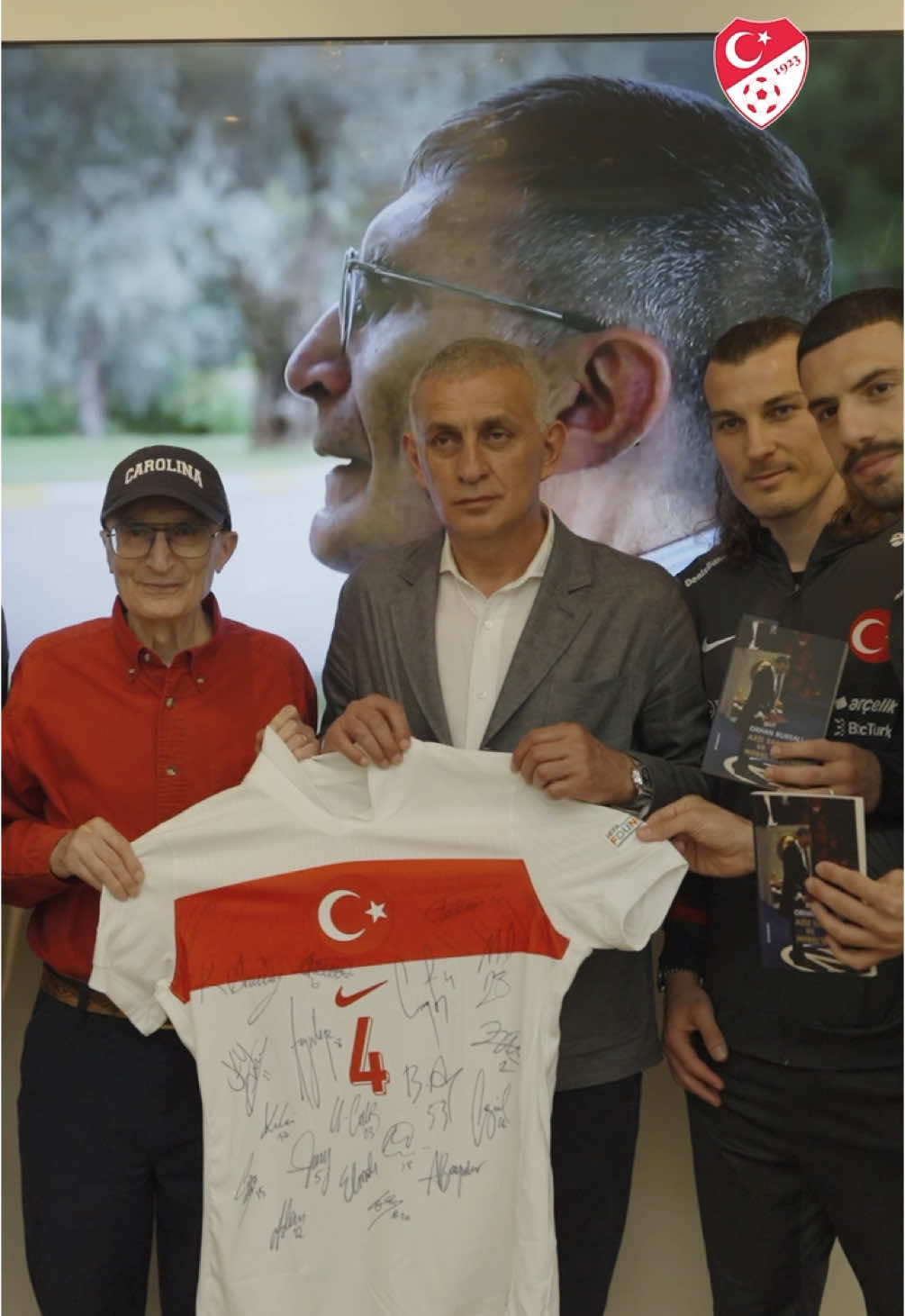 A post by @millitakimlar on TikTok caption: TFF Başkanı İbrahim Ethem Hacıosmanoğlu ve beraberindeki A Millî Takım heyeti, Nobel Kimya Ödülü sahibi Türk bilim insanı Prof. Dr. Aziz Sancar'ı ABD'de ziyaret etti.