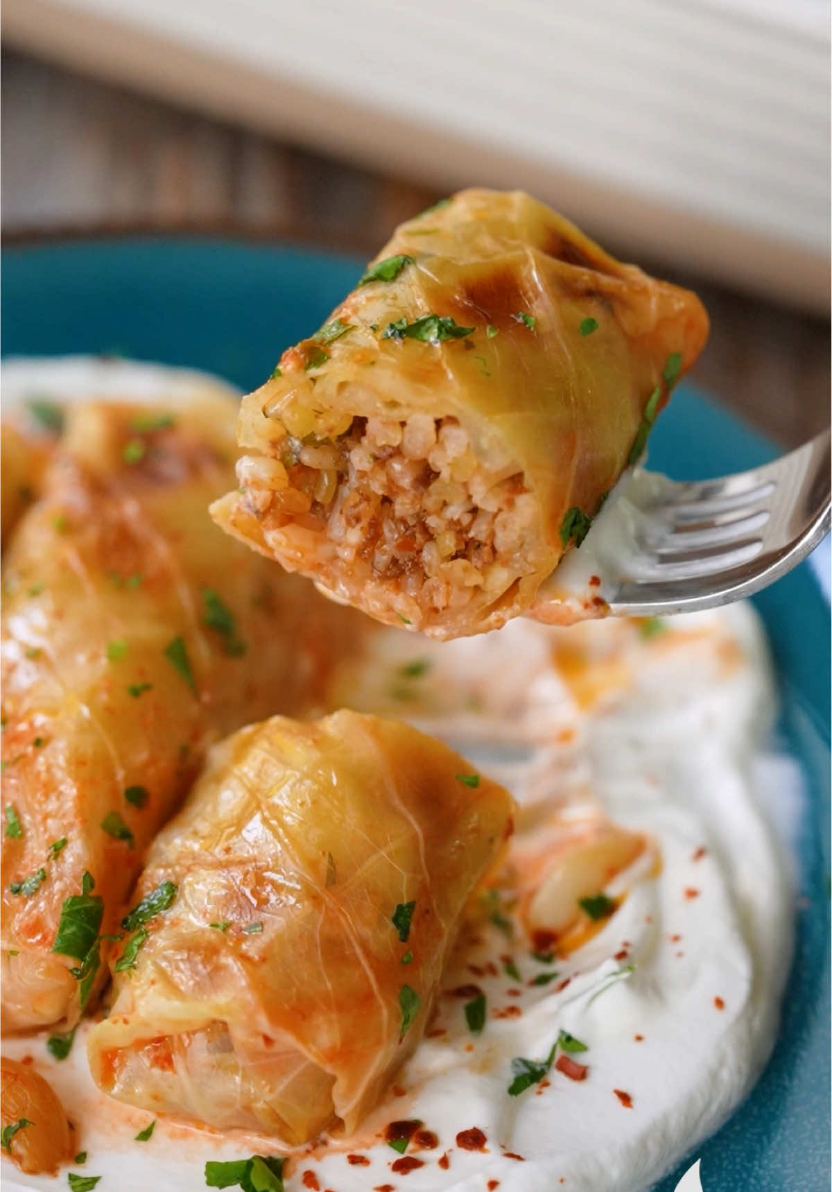 A post by @nefisyemektarifleri on TikTok caption: Bir de böyle deneyin: Fırında Lahana Sarma 🤩 Malzemeler 1 adet küçük boy beyaz lahana İç harcı için; 200 g kıyma 1 çay bardağı pirinç 1 çay bardağı bulgur 1 adet kuru soğan Yarım su bardağı sıvı yağ (100 ml) 1 yemek kaşığı domates salçası 1 tatlı kaşığı tuz 1 çay kaşığı pul biber 1 çay kaşığı karabiber Çeyrek demet maydanoz Sosu için; 1 yemek kaşığı biber salçası 2 su bardağı sıcak su (400 ml) 1 çay kaşığı tuz Üzeri için; Tereyağı Sarımsak Hazırlanışı Öncelikle kök kısmını oyarak çıkarttığımız lahanayı tencereye alalım. Üzerine sıcak su ekleyerek lahana yapraklarını yumuşayana kadar çevirerek haşlayalım. Alt ve üst tarafını 10’ar dakika haşlamak yeterli olacaktır. Ancak yine de kontrol ederek almanızda fayda var. İç harcı için karıştırma kabına kıyma, bulgur, yıkanmış pirinç, yemeklik doğranmış soğan, maydanoz, domates salçası, baharatlar, tuz, sıvı yağı ekleyerek güzelce karıştıralım. Damarlarını kestiğimiz lahana yapraklarının üzerlerine iç harcından yerleştirelim ve saralım. Tüm harcı aynı şekilde sararak fırın tepsisine sıralayalım. Üzerlerine salça, sıcak su ve tuzu karıştırarak hazırladığımız sosu gezdirelim. Tereyağı ve sarımsak yerleştirip üzerini ıslattığımız pişirme kağıdı ile kapatarak 180 °C fırında, alt üst fansız ayarda 1 saat pişmeye bırakalım. Pişen lahana sarmalarını fırından alalım. İsteğe bağlı yoğurt eşliğinde servis edelim. Afiyet olsun!